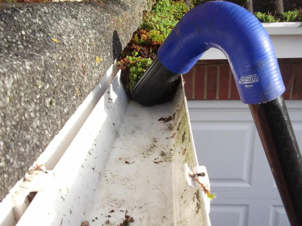 Gutter vac in action removing heavy moss